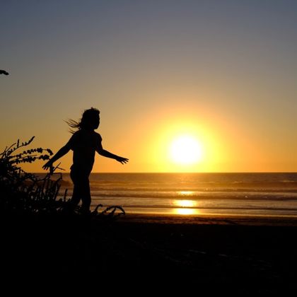 Jessie als Silhouette vor dem Sonnenuntergang am Meer